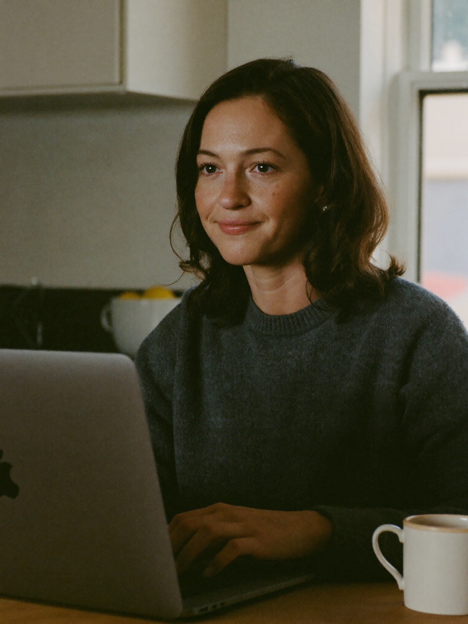 Sarah on a video telehealth consultation at her kitchen table